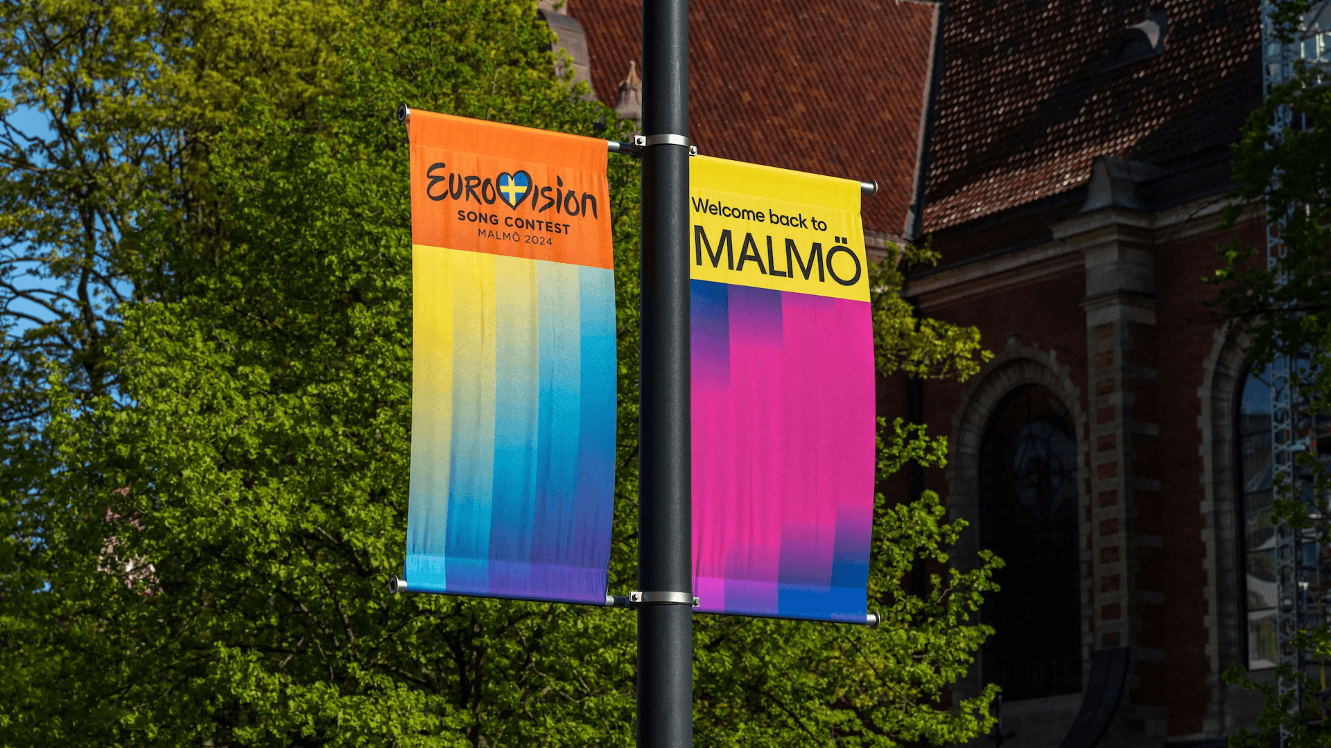 2 banners hanging from a pole showcasing the Eurovision 2024 identity.